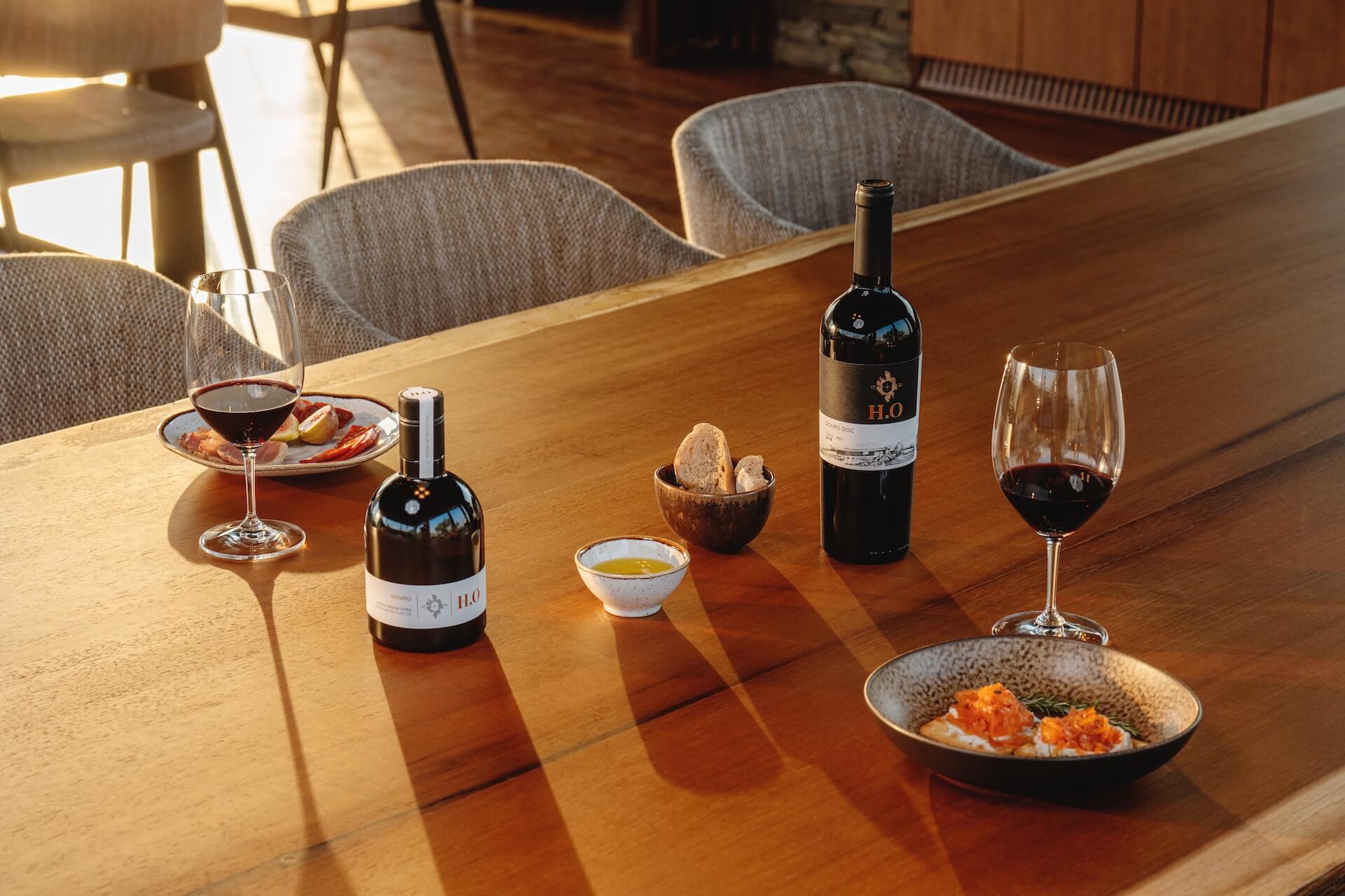 Mesa na adega da Horta Osório com vinho e azeite H.O